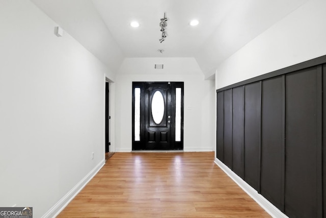 entryway with light hardwood / wood-style flooring and vaulted ceiling