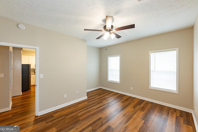 unfurnished room with dark hardwood / wood-style floors, ceiling fan, and a textured ceiling