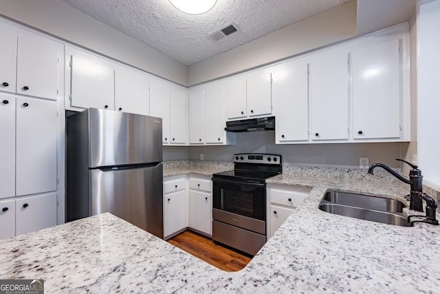 kitchen featuring white cabinetry, sink, stainless steel appliances, and a textured ceiling