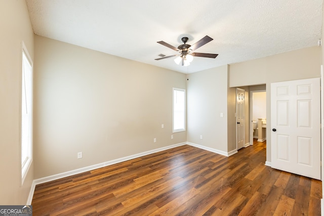 unfurnished room featuring ceiling fan, dark wood-type flooring, and a textured ceiling