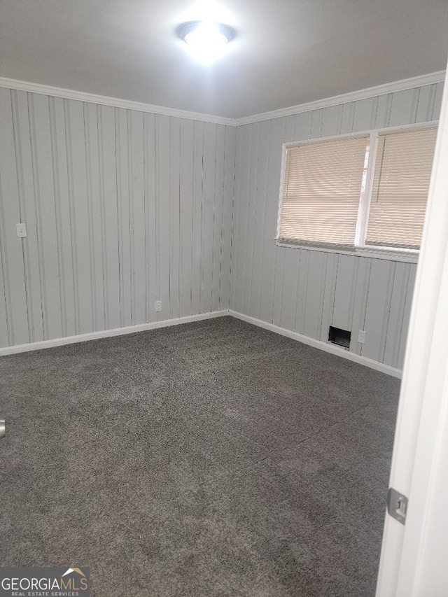 carpeted empty room featuring crown molding