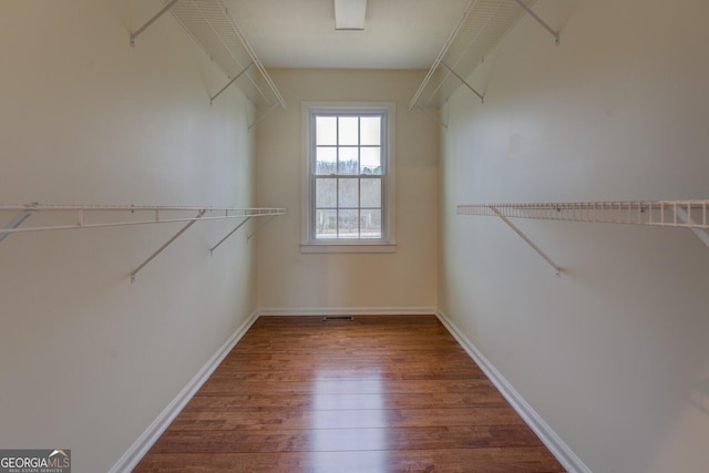 spacious closet featuring dark wood finished floors