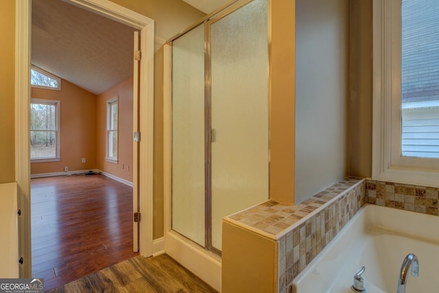 12178 Brown Bridge Rd, Covington, GA 30016 - full bathroom featuring lofted ceiling, a shower stall, wood finished floors, and a bath