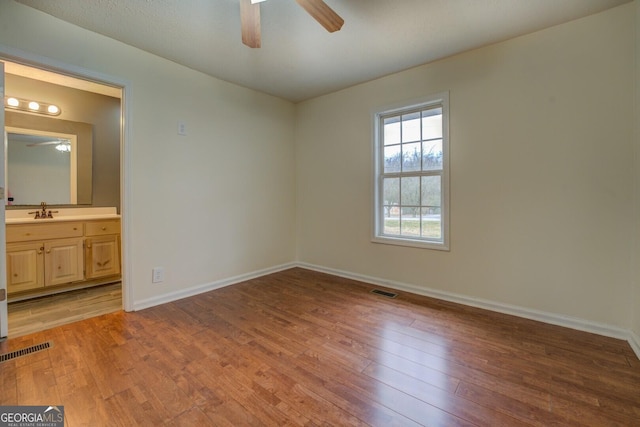 12178 Brown Bridge Rd, Covington, GA 30016 - unfurnished bedroom featuring light wood-type flooring, connected bathroom, and a ceiling fan
