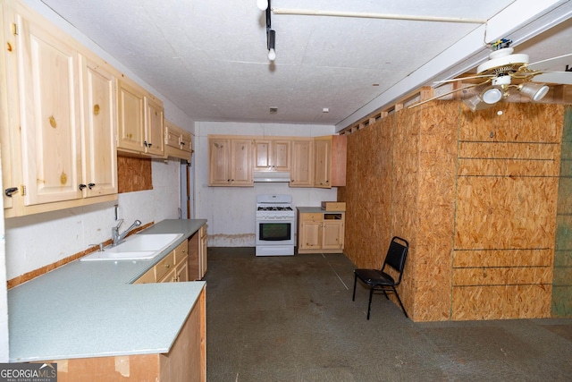 kitchen with under cabinet range hood, a sink, white range with gas cooktop, light countertops, and light brown cabinetry