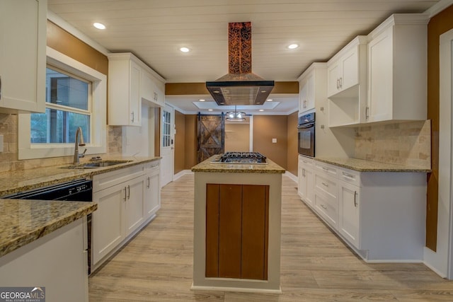 kitchen featuring light stone counters, a center island, white cabinetry, and black appliances