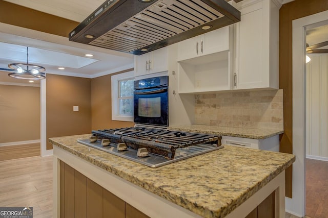 kitchen featuring light stone counters, white cabinets, black oven, custom exhaust hood, and stainless steel gas stovetop