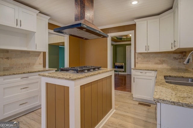 12178 Brown Bridge Rd, Covington, GA 30016 - kitchen with island range hood, stainless steel gas stovetop, white cabinets, light wood finished floors, and recessed lighting
