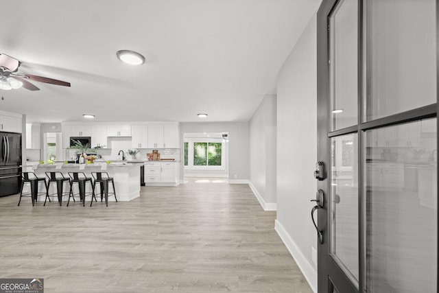 interior space with light wood-type flooring, ceiling fan, and sink