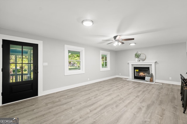 unfurnished living room featuring ceiling fan and light hardwood / wood-style floors