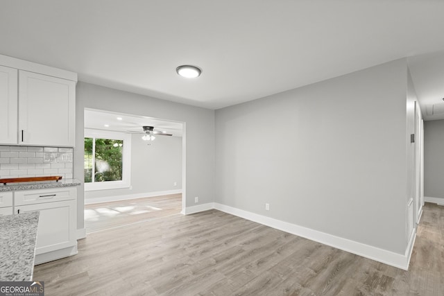 unfurnished living room featuring ceiling fan and light wood-type flooring