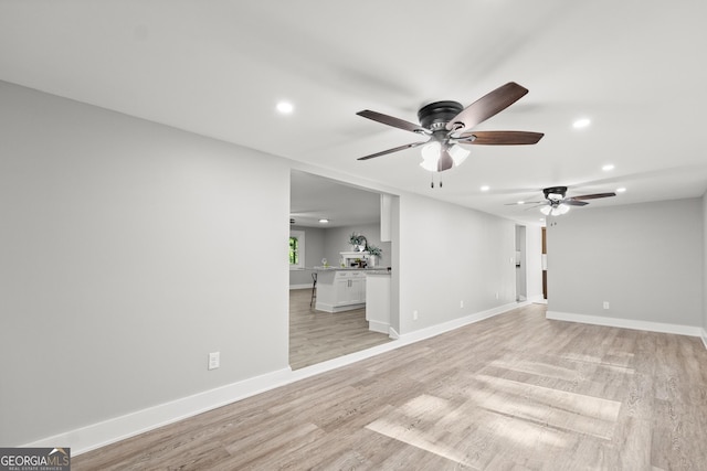 unfurnished living room featuring light wood-type flooring and ceiling fan