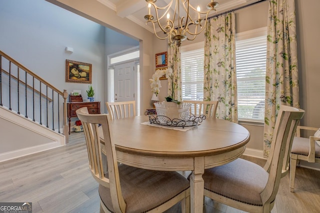 dining space featuring light wood-style flooring, a notable chandelier, baseboards, stairs, and ornamental molding