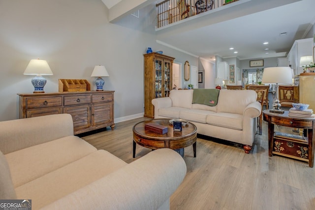 living room with ornamental molding, recessed lighting, light wood-style flooring, and baseboards