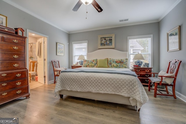 bedroom with baseboards, hardwood / wood-style flooring, visible vents, and crown molding