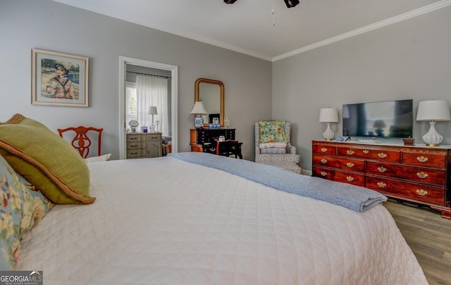 bedroom with crown molding, ceiling fan, and wood finished floors