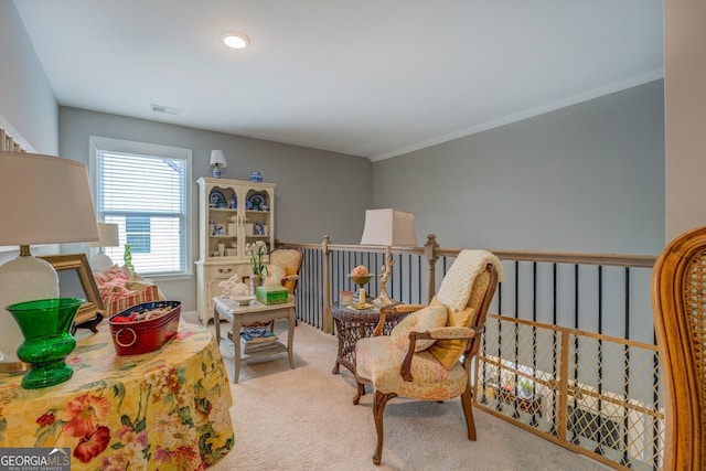 living area with ornamental molding, carpet flooring, visible vents, and an upstairs landing