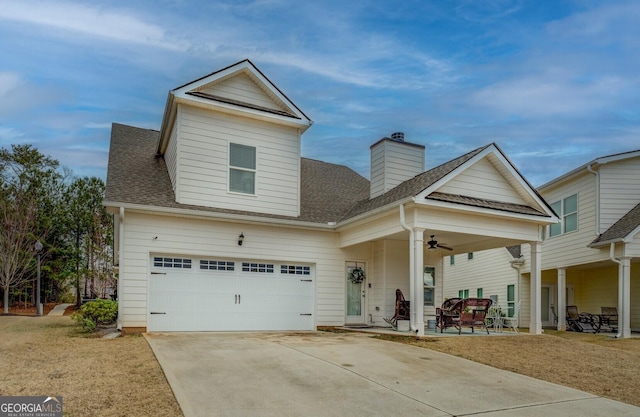 view of front of house with ceiling fan, a patio, a shingled roof, concrete driveway, and a chimney