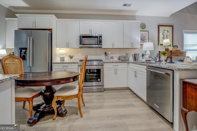 kitchen with premium appliances, visible vents, crown molding, and backsplash