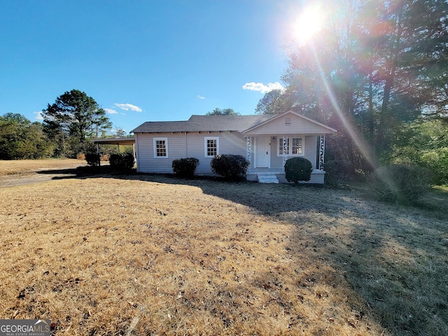 ranch-style home with a front yard and a carport