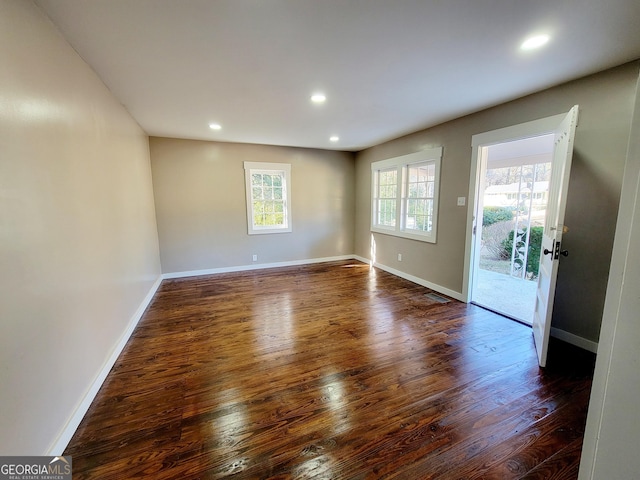 empty room featuring dark hardwood / wood-style flooring and a healthy amount of sunlight