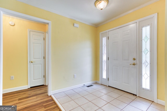 tiled entrance foyer featuring ornamental molding