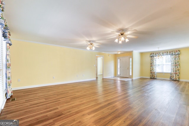 empty room featuring wood-type flooring and ceiling fan with notable chandelier