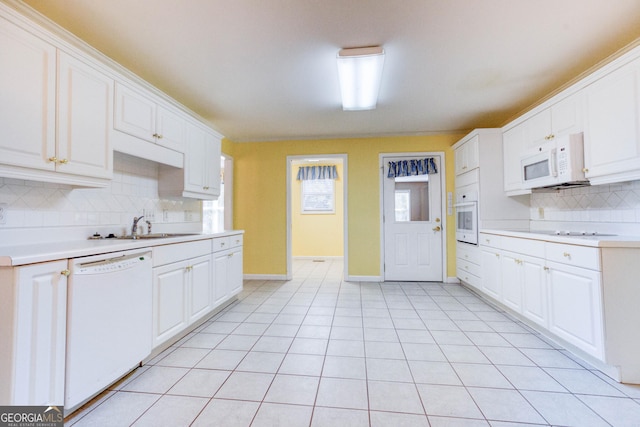 kitchen featuring tasteful backsplash, white cabinetry, light tile patterned floors, and white appliances