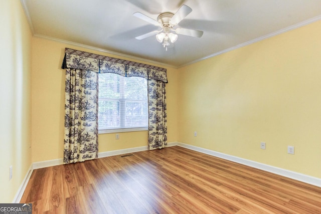 spare room with crown molding, ceiling fan, and wood-type flooring