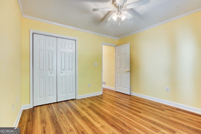 unfurnished bedroom featuring ceiling fan, a closet, light wood-type flooring, and ornamental molding