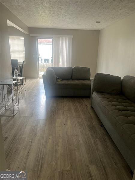 living room featuring hardwood / wood-style floors and a textured ceiling