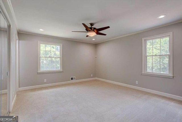 carpeted empty room featuring plenty of natural light, ceiling fan, and ornamental molding