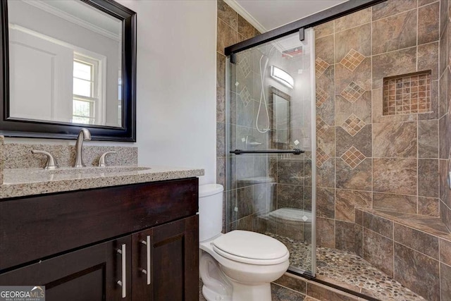 bathroom with crown molding, vanity, an enclosed shower, and toilet