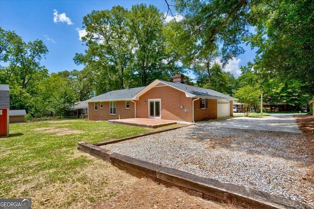 back of property with a patio area, a yard, and a garage