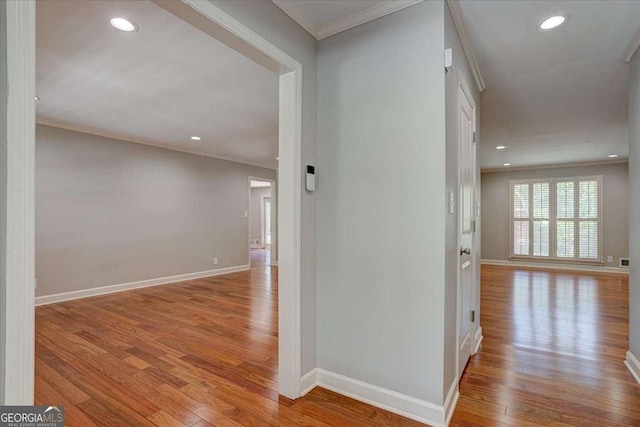 hallway featuring crown molding and light hardwood / wood-style floors