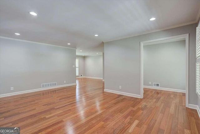 empty room featuring light hardwood / wood-style floors and ornamental molding