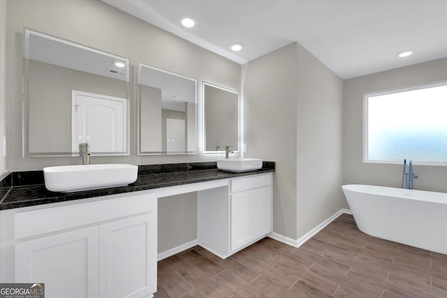 bathroom with a tub to relax in and vanity