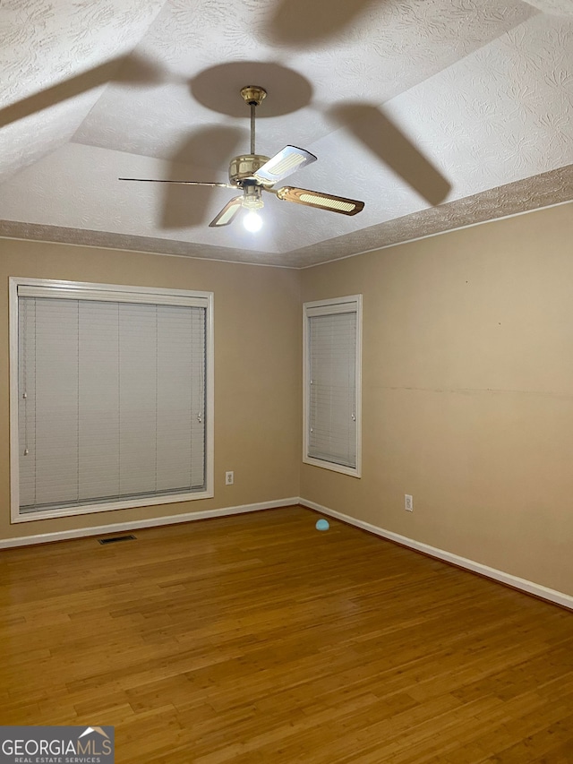 interior space featuring ceiling fan, wood-type flooring, and a textured ceiling