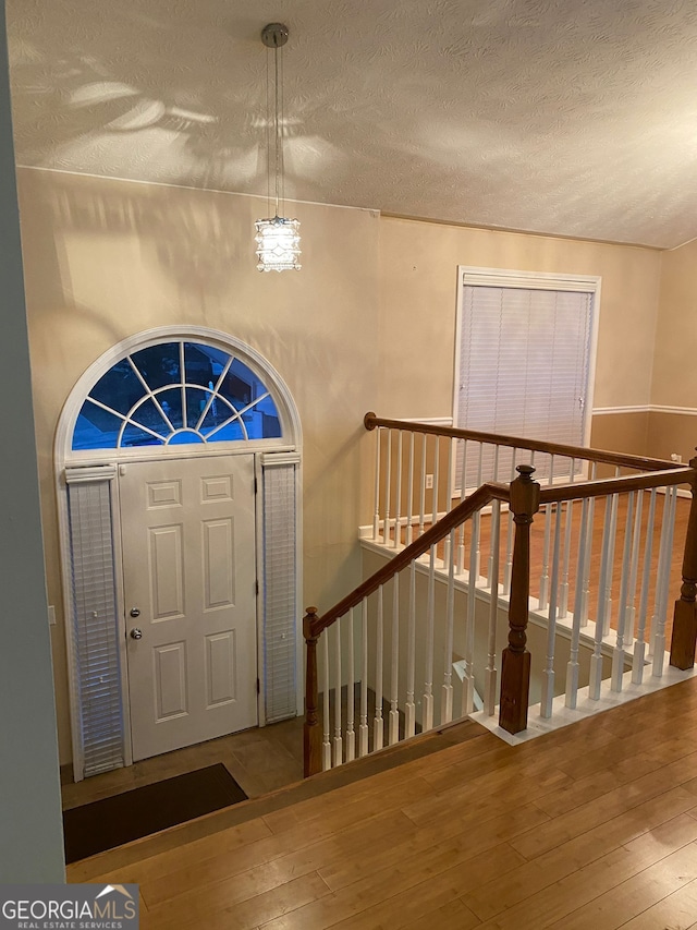 entrance foyer with a textured ceiling and hardwood / wood-style floors