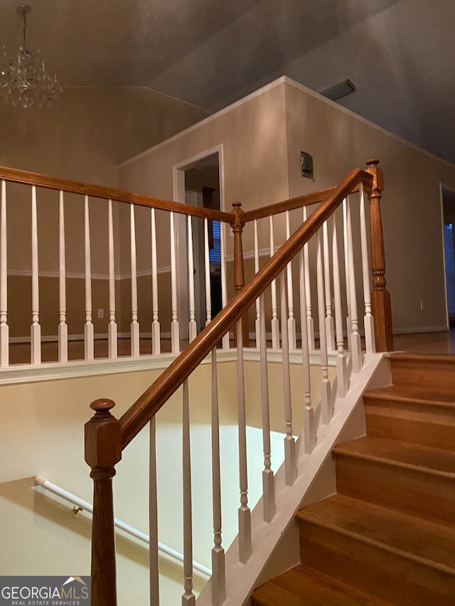 staircase with vaulted ceiling and an inviting chandelier