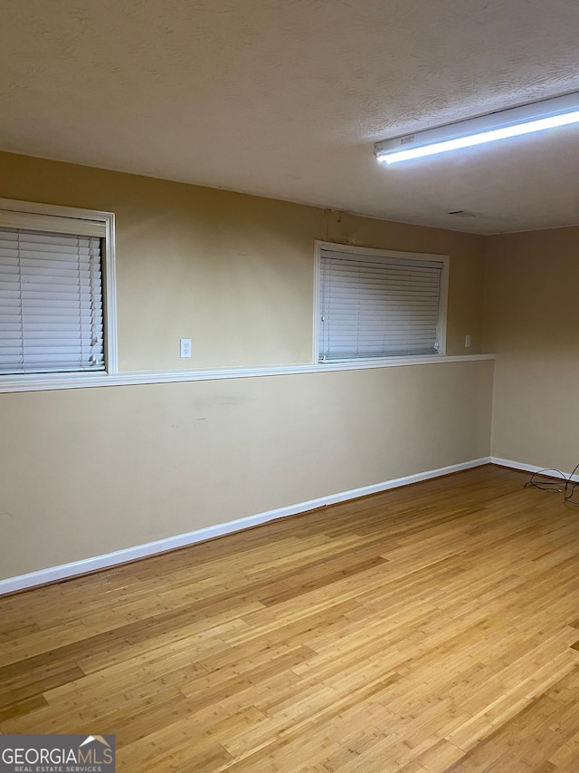 empty room featuring light hardwood / wood-style floors and a textured ceiling