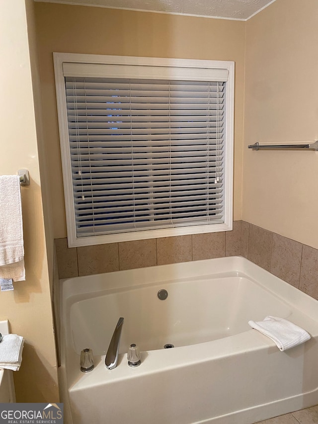 bathroom featuring a washtub and a textured ceiling