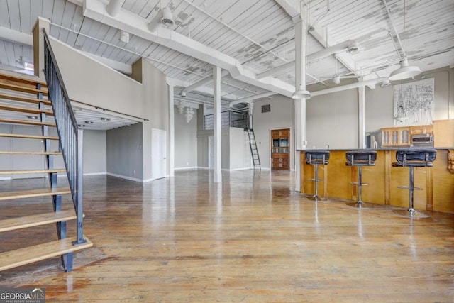 interior space with wood-type flooring and a towering ceiling