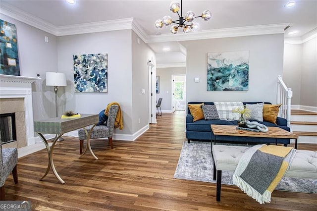 living room with a fireplace, hardwood / wood-style flooring, crown molding, and a notable chandelier