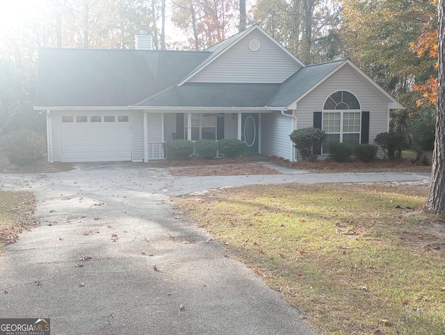 front facade with a porch, a garage, and a front lawn