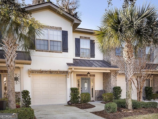 view of front of house featuring a standing seam roof, an attached garage, metal roof, and stucco siding