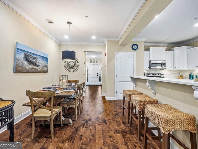 dining area featuring dark hardwood / wood-style flooring, ceiling fan, crown molding, and sink