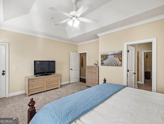 carpeted bedroom with ceiling fan, ornamental molding, a textured ceiling, connected bathroom, and a tray ceiling