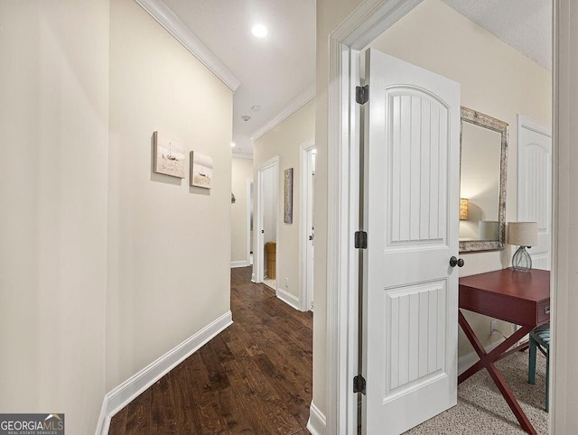 hall with dark wood-type flooring and crown molding