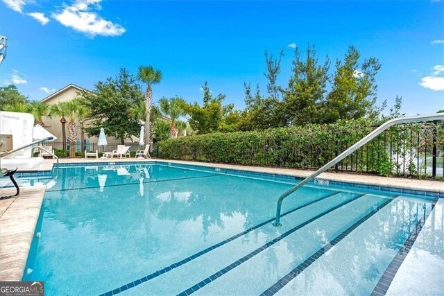 view of pool featuring a storage unit and a patio area